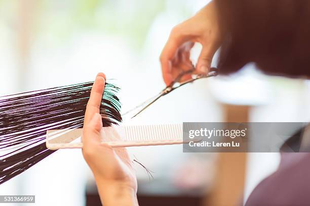 hairdresser using scissors to cut hair - hair cut stockfoto's en -beelden
