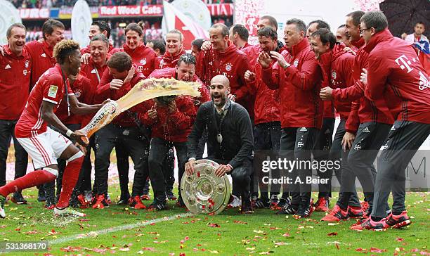 Team coach Josep Guardiola of Bayern Muenchen receives a beer shower from David Alaba during the German Championship celebration after the Bundesliga...