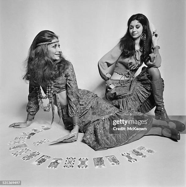 Models Susie Trotter and Dona McDonna display a long ruffled skirt, brief top, and beads, 7th November 1969.