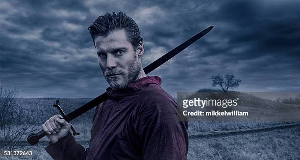 retrato de viking warrior sostiene una espada - viking warrior fotografías e imágenes de stock