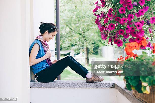 girl using tablet at the veranda - hanging basket stock pictures, royalty-free photos & images