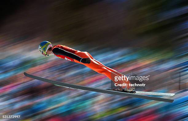 ski jumper in der luft gegen verschwommen hintergrund - ski jumping stock-fotos und bilder