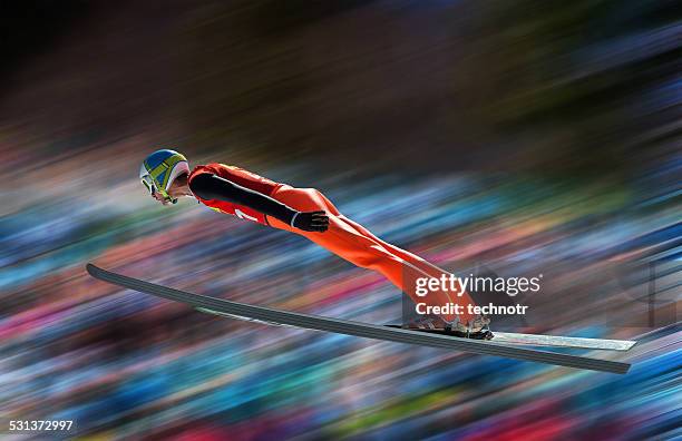 ski jumper in der luft gegen verschwommen hintergrund - mitziehen stock-fotos und bilder