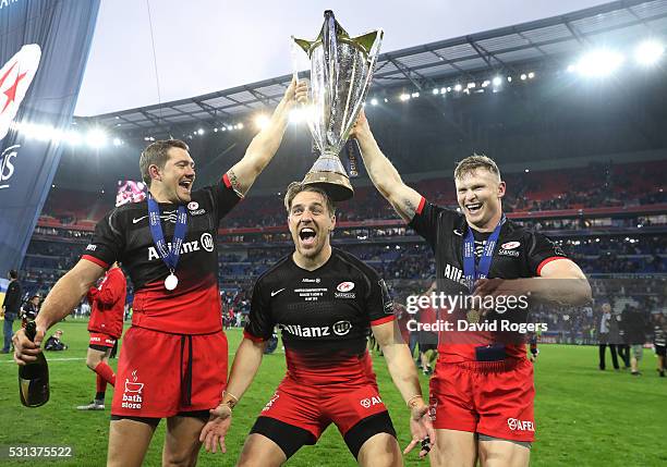 Alex Goode , Chris Wyles and Chris Ashton of Saracens celebrate with the trophy after the European Rugby Champions Cup Final match between Racing 92...