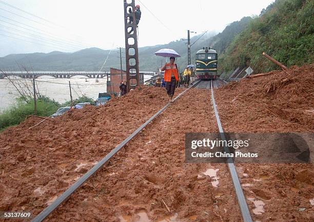 Rescue workers repair a railway after a landslide triggered by flood on June 22, 2005 in Shunchang County of Fujian Province, southeast China....