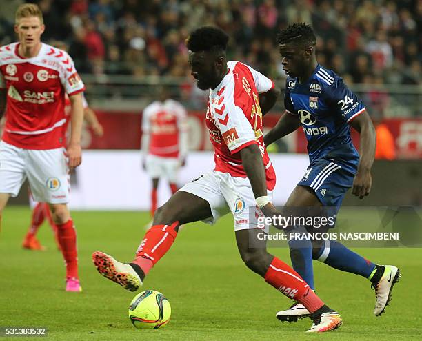 Reims' French forward Grejohn Kyei vies with Lyon's French midfielder Olivier Kemen R) during the French Ligue 1 football match between Reims and...