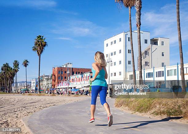 woman jogging un venice beach - venice beach stock pictures, royalty-free photos & images