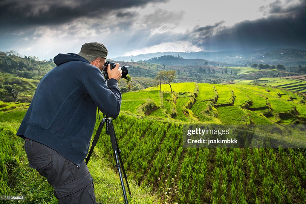 Landscape photographer taking photos of ricefield