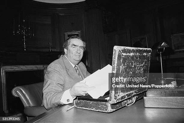 British Labour party politician and Chancellor of the Exchequer, Denis Healey pictured putting papers in to the red budget box prior to his budget...