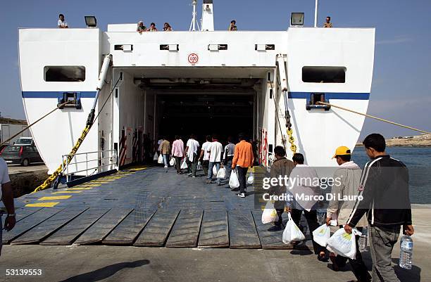 Illegal immigrants embark on a ferry boat to Sicily to be deported to a temporary holding center for foreign nationals June 17, 2005 in Lampedusa,...