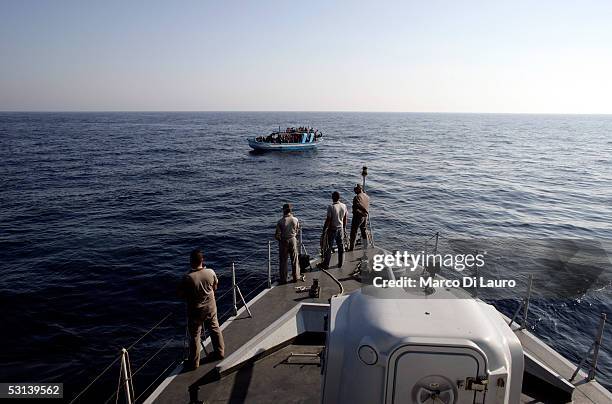 An Italian customs Police "Guardia di Finanza" boat approach a boat loaded with illegal Immigrants on June 21, 2005 in Lampedusa, Italy. Tens of...