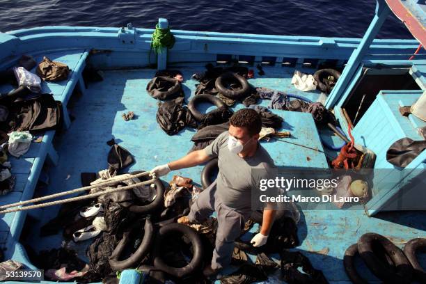 An Italian custom Police "Guardia di Finanza" officer inspect a boat that was loaded with illegal immigrants after they were taken on board on June...