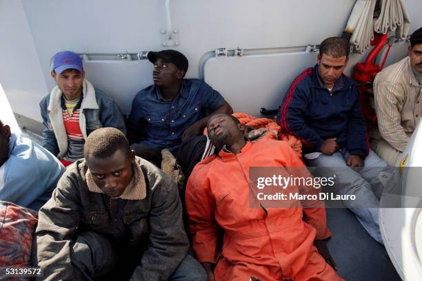 Illegal Immigrants are seen on a boat of Italian custom Police "Guardia di Finanza" after they were taken on board on June 21, 2005 in Lampedusa,...