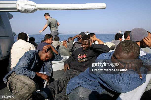 Illegal Immigrants are seen on a boat of Italian custom Police "Guardia di Finanza" after they were taken on board on June 21, 2005 in Lampedusa,...