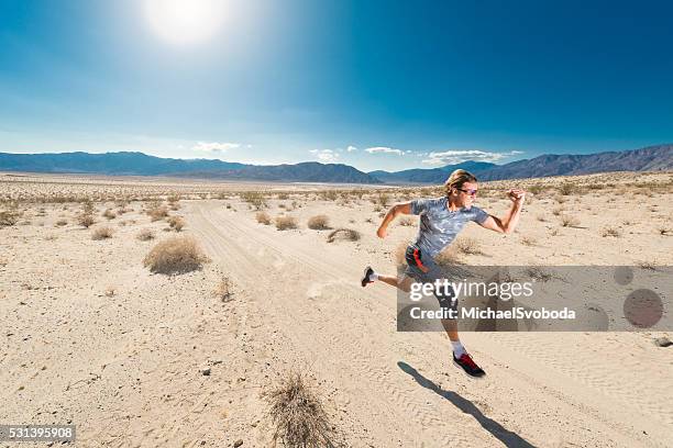 man with knee brace running in the desert - knee brace stock pictures, royalty-free photos & images