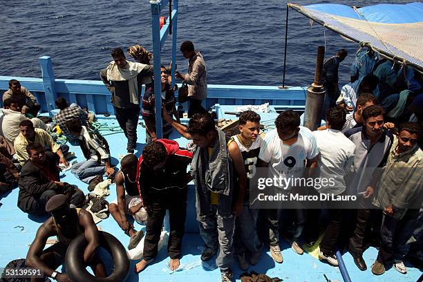 Illegal immigrants wait to be taken on board by a boat of Italian Custom Police "Guardia di Finanza" on June 21, 2005 in Lampedusa, Italy. Tens of...