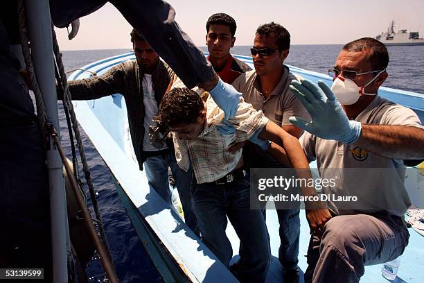 Italian custom Police "Guardia di Finanza" Officers take on board an unconcious illegal Immigrant on June 21, 2005 in Lampedusa, Italy. Tens of...