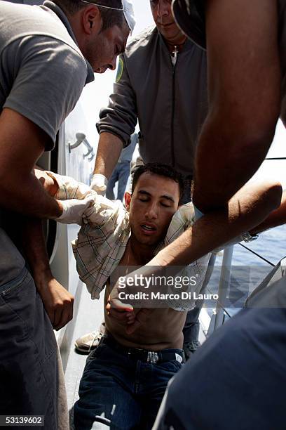 Italian custom Police "Guardia di Finanza" Officers take on board an unconcious illegal Immigrant on June 21, 2005 in Lampedusa, Italy. Tens of...