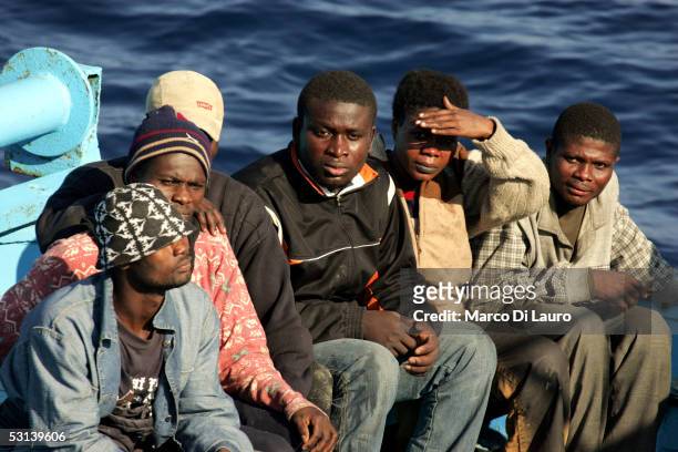 Illegal immigrants wait to be taken on board by a boat of Italian Custom Police "Guardia di Finanza" on June 21, 2005 in Lampedusa, Italy. Tens of...
