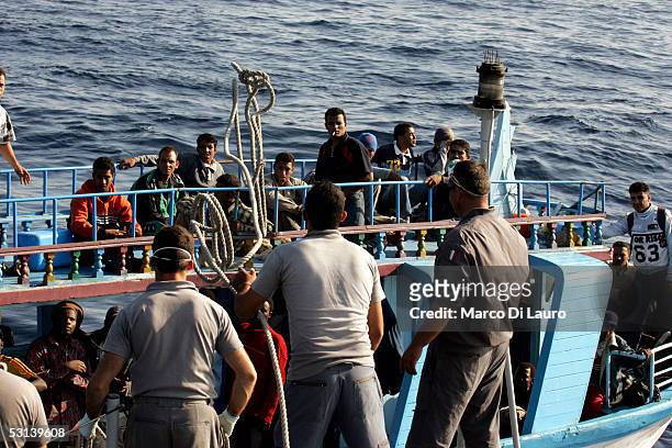 Italian Custom Police "Guardia di Finanza" approach a boat loaded with illegal immigrants on June 21, 2005 in Lampedusa, Italy. Tens of thousands of...