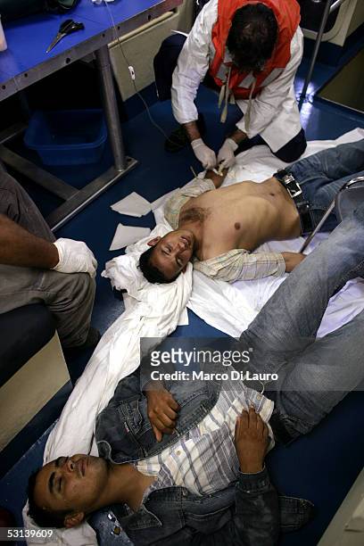An Italian custom Police "Guardia di Finanza" Officer and an Italian Navy doctor tend to an unconcious illegal immigrants after they were taken on...