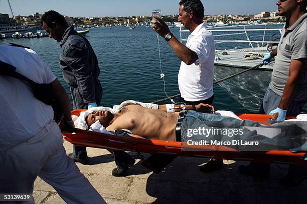 An unconcious Illegal immigrant is taken to a temporary holding center for foreign nationals on June 21, 2005 in Lampedusa, Italy. Tens of thousands...