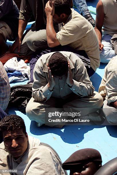 Illegal immigrants wait to be taken on board a boat of Italian Custom Police "Guardia di Finanza" on June 21, 2005 in Lampedusa, Italy. Tens of...