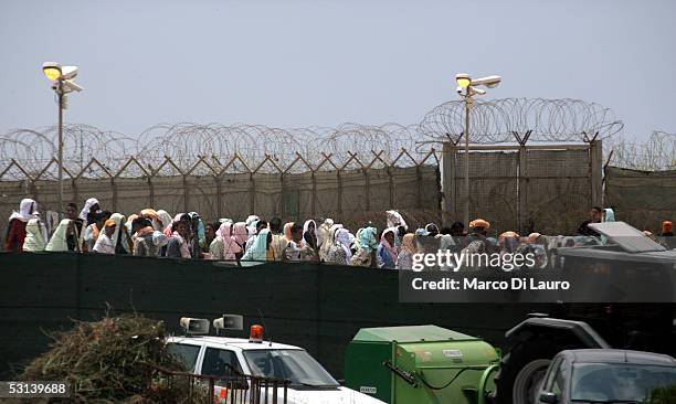 Illegal immigrants are seen in the temporary holding center for foreign nationals on June 22, 2005 in Lampedusa, Italy. Tens of thousands of...