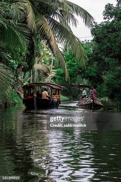 indian man transporting soil in the boat. - kumarakom stockfoto's en -beelden