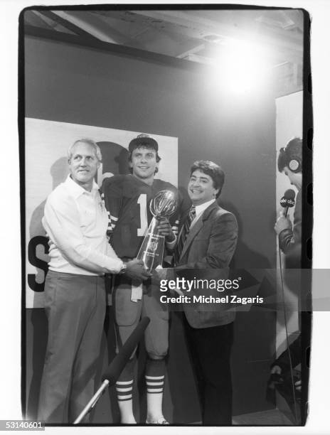 San Francisco 49ers head coach Bill Walsh, Joe Montana and owner Edward J. DeBartolo Jr. Hold the Vince Lombardi Trophy following Super Bowl XIX...