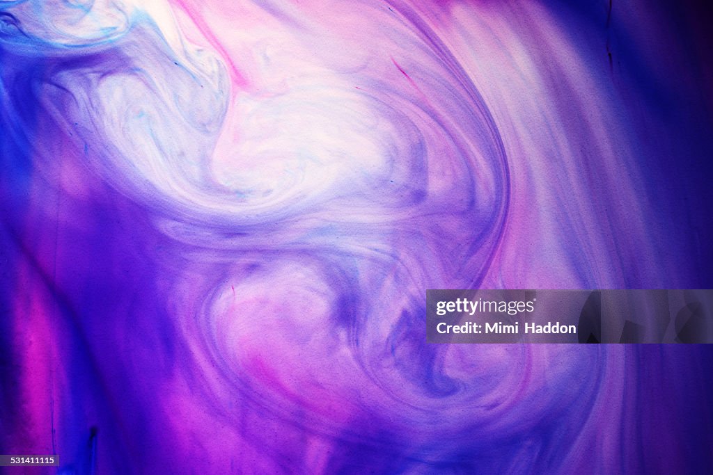 Blue and Purple Dyes Swirling in Liquid