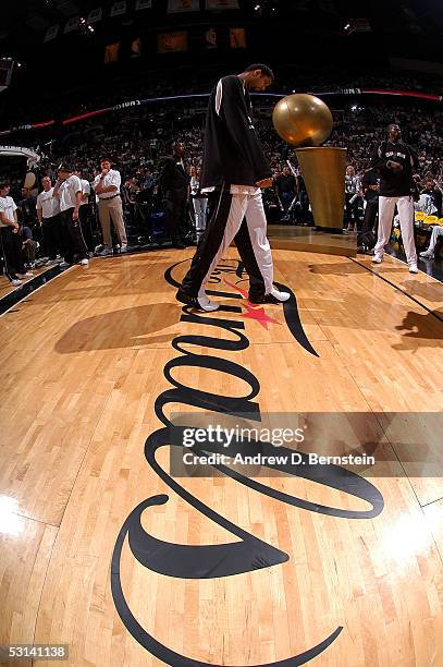 Tim Duncan of the San Antonio Spurs paces in front of a giant replica of the Larry O'Brien NBA Championship trophy against the Detroit Pistons in...