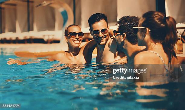 la gente disfruta de bebidas junto a la piscina. - fiesta de piscina fotografías e imágenes de stock