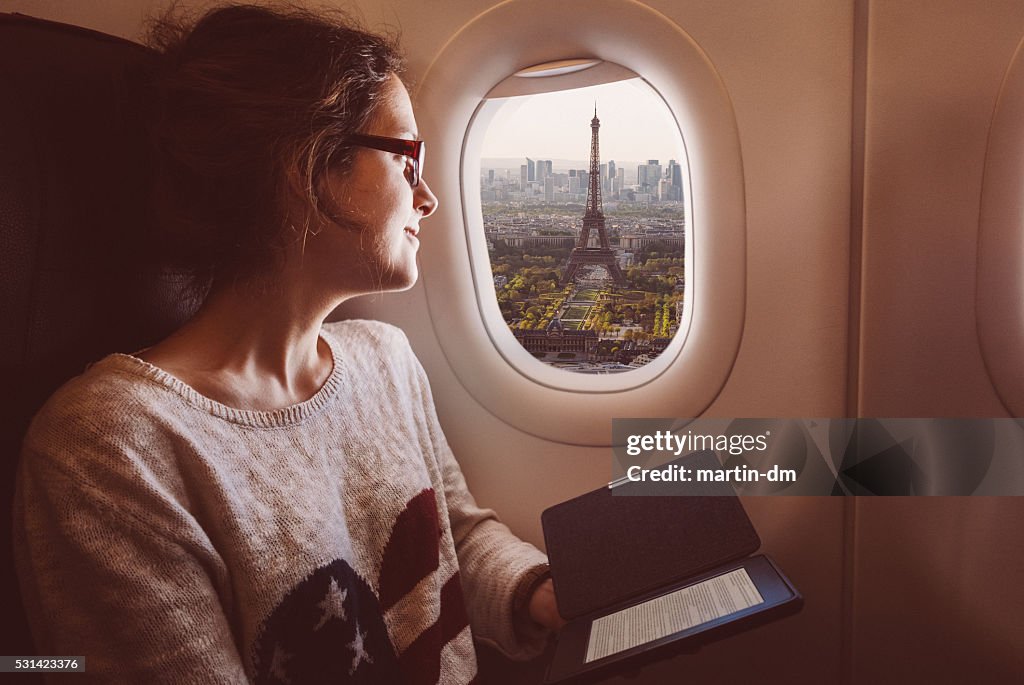 Donna con e-book nella aereo viaggio a Parigi