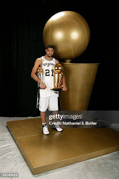 Tim Duncan of the San Antonio Spurs poses for a portrait with the Larry O'Brien Championship trophy and his 2005 Finals MVP trophy following Game...