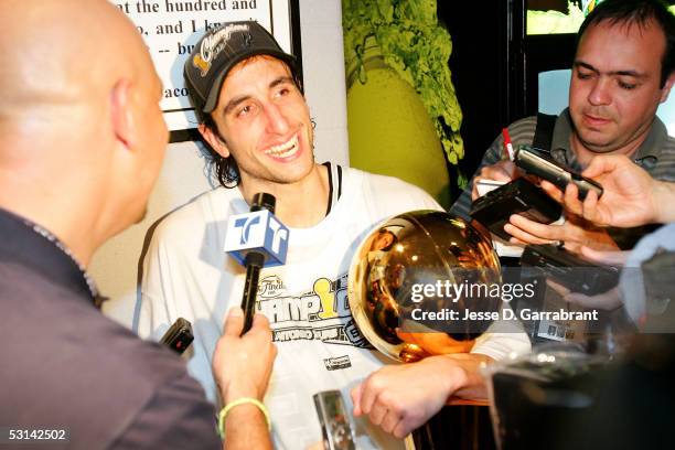 Manu Ginobili of the San Antonio Spurs holds the Larry O'Brein NBA Championship trophy as he is interviewed following the Spurs 81-74 win against the...