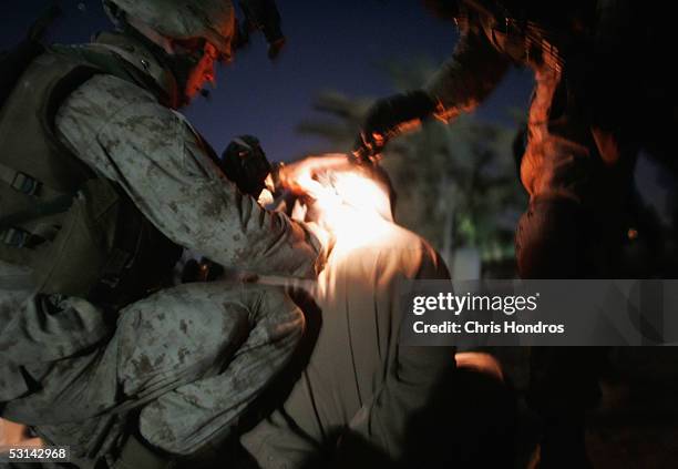 Marines write a number on the nape of the neck of a man they have detained in a sweep June 24, 2005 near Fallujah, Iraq. Marines in the 3/4 launched...