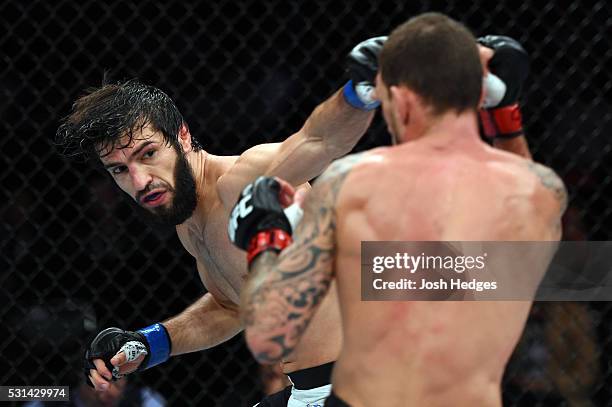 Zubaira Tukhugov of Russia punches Renato Moicano of Brazil in their featherweight bout during the UFC 198 event at Arena da Baixada stadium on May...