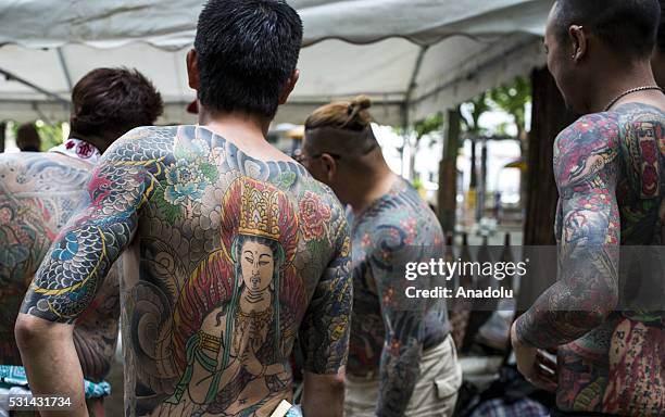 Yakuza members proudly display their tattoos during the second day of the Sanja Matsuri Festival in Tokyo's Asakusa district on May 14, 2016. This...