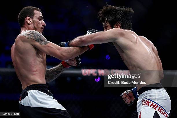 Zubaira Tukhugov of Russia punches Renato Mocaio of Brazil in their featherweight bout during the UFC 198 at Arena da Baixada stadium on May 14, 2016...