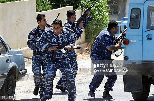 Palestinian security forces take cover as they return fire during an operation to arrest armed militants in the northern West Bank city of Jenin 24...