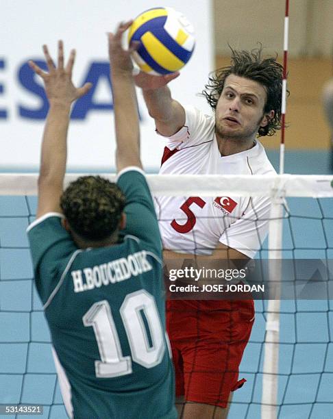 Turkish Soner Mezgitci hits the ball as Hicham Bouchoduk from Morocco tries to block him during their volleyball match of the XV Mediterranean Games,...
