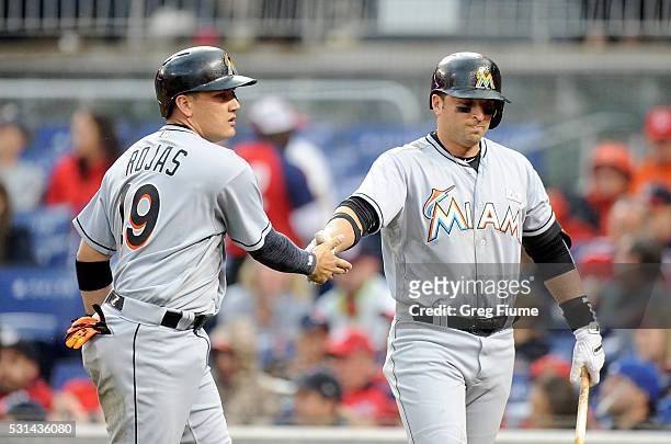 Miguel Rojas of the Miami Marlins celebrates with Martin Prado after scoring in the second inning against the Washington Nationals at Nationals Park...