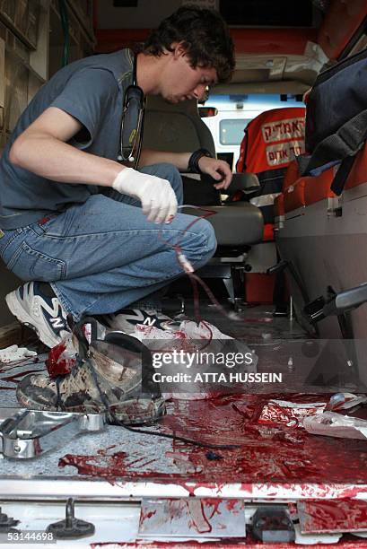 An Israeli medic in plain clothes is seen in a blood stained ambulance after a man wounded in a shooting attack near the Jewish settlement of Beit...