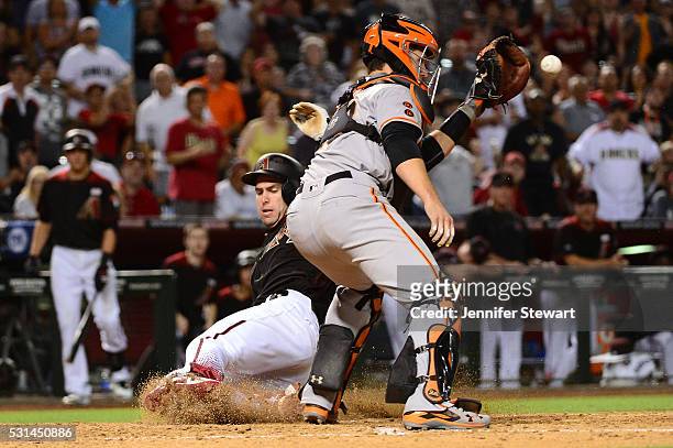 Paul Goldschmidt of the Arizona Diamondbacks safely slides into home in front of Buster Posey of the San Francisco Giants in the eighth inning at...