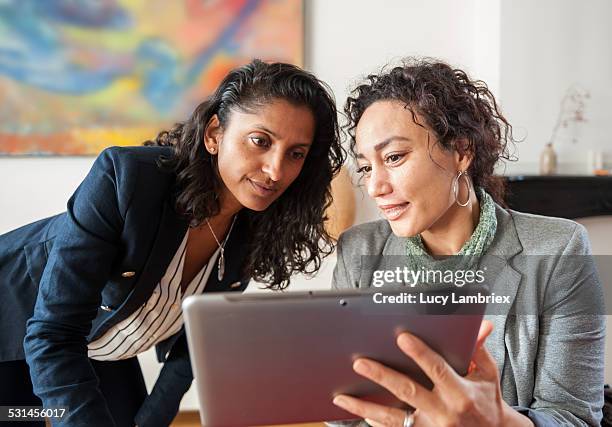 two business women with tablet computer - office workers collaborating stockfoto's en -beelden