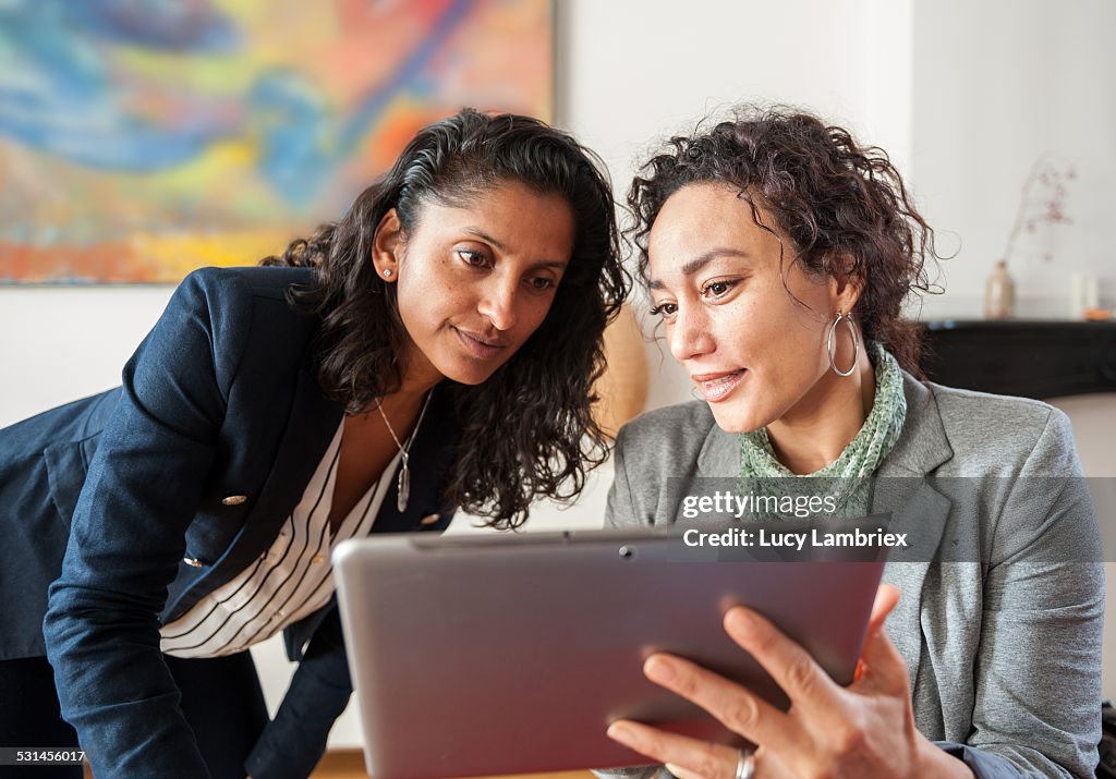 Two business women with tablet computer