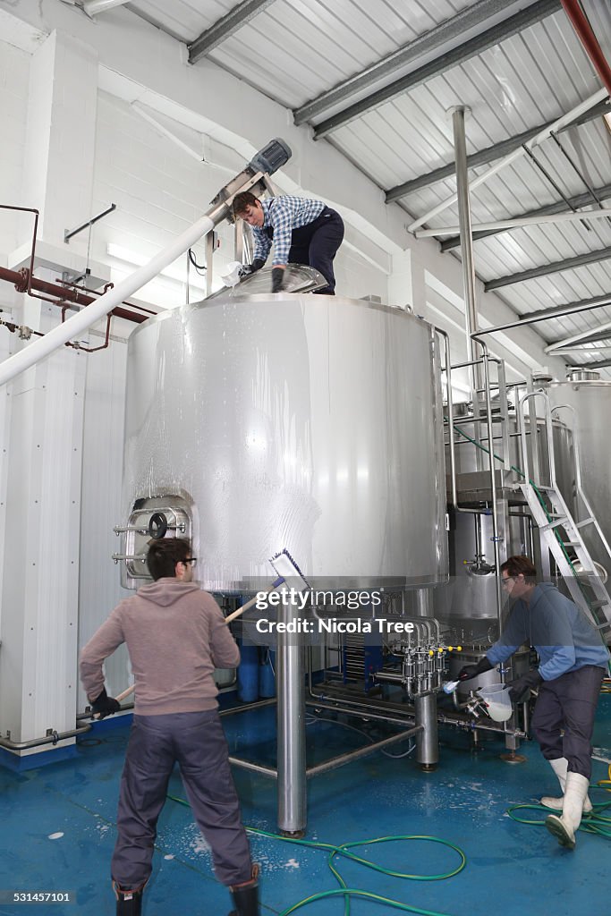 Workers in a micro brewery steralising the tanks