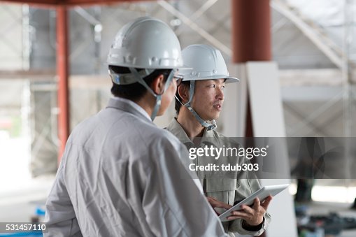 Two engineers discussing while using a digital tablet Two engineers discussing while using a digital tablet