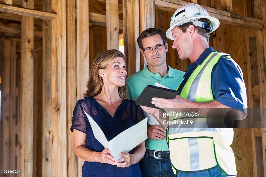 Generatore di casa parlando con coppia su Cantiere di costruzione